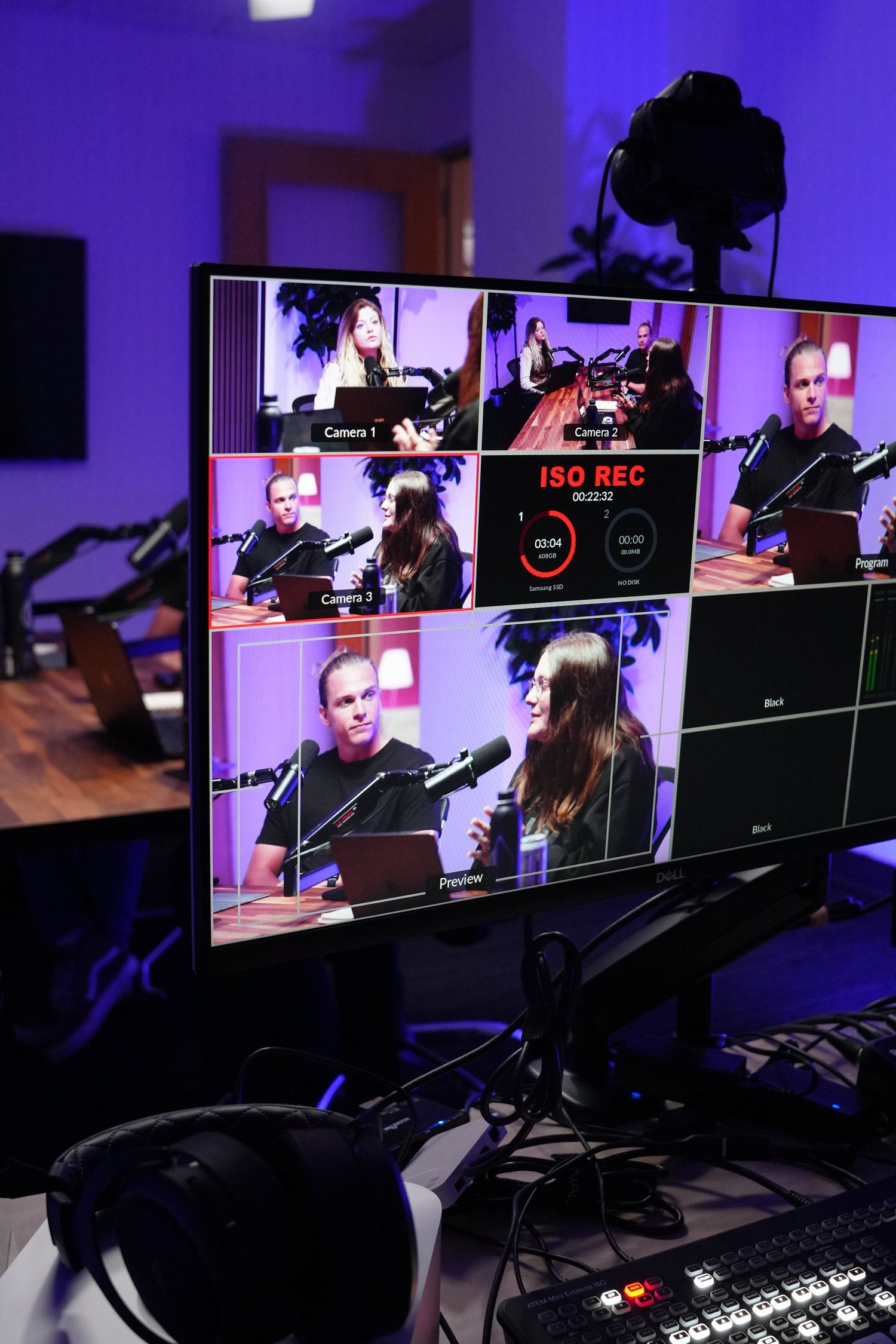 Video production control monitor showing four people in a studio